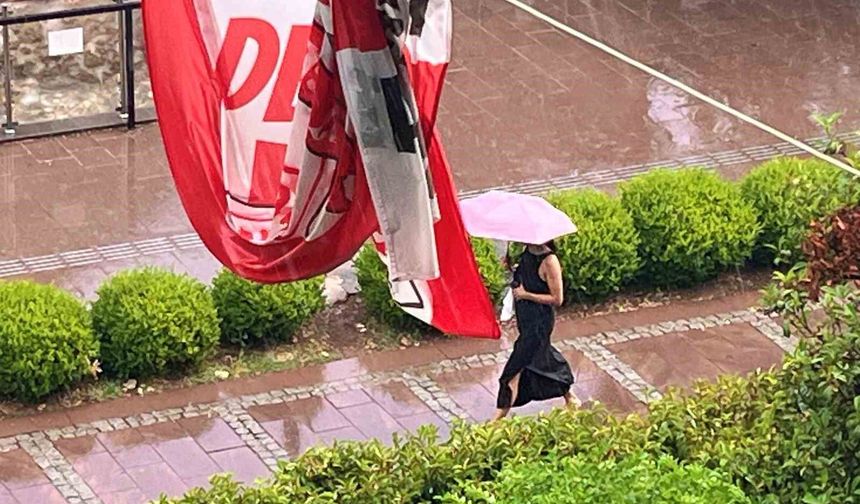 Antalya'da aniden bastıran yağmur, tatilcilere temmuz ayında şemsiye açtırdı