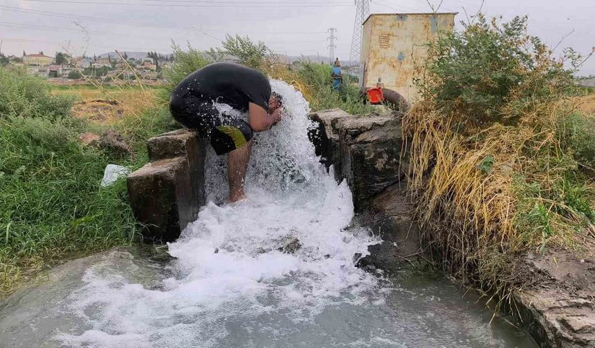 Kavurucu sıcakta elbisesini bile çıkarmadan buz gibi sondaj suyunda serinledi